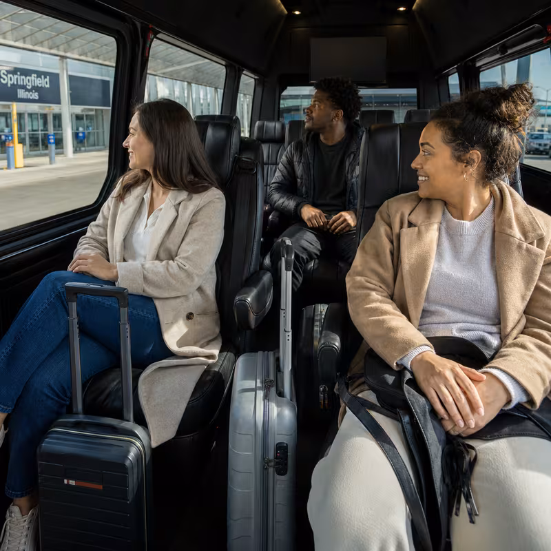 Passengers loading luggage while boarding an Springfield group shuttle